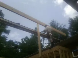 Carpenter setting a ridge beam over a new addition frame — Ice Dam Removal by Roofing Brothers in Eglon