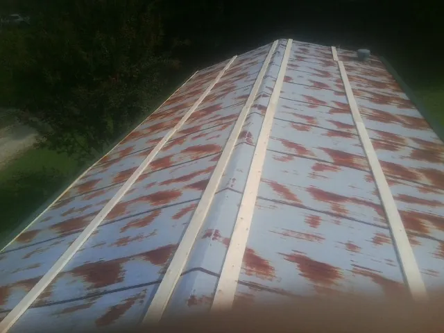 Rusted metal roof panels with new wood purlins before replacement — Storm Damage Roof Repair in Eglon by Roofing Brothers