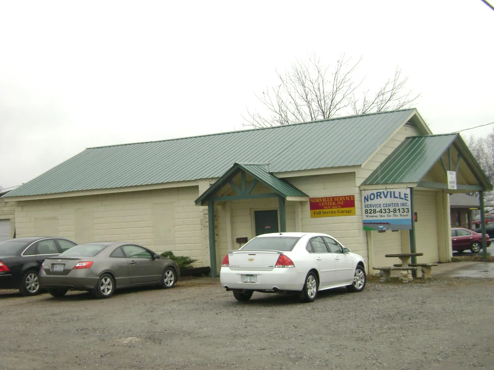 Green metal roof on a service garage with a covered entry in Eglon