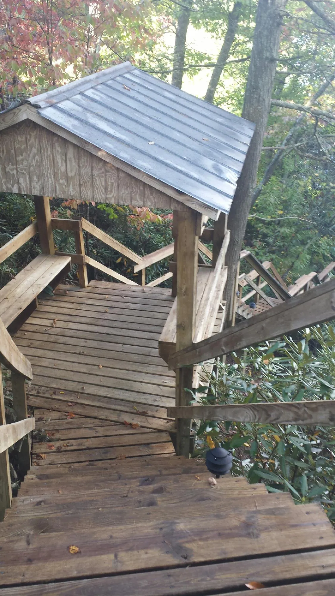 Metal roofed shelter over wooden steps on a wooded walkway — Skylight Repair & Installation work by our crew in Eglon